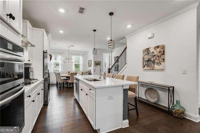 6635 Beacon Dr, Atlanta, GA 30328 - kitchen with a kitchen breakfast bar, appliances with stainless steel finishes, white cabinets, light countertops, and a center island with sink