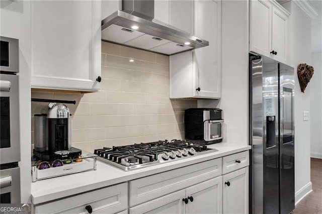 6635 Beacon Dr, Atlanta, GA 30328 - kitchen featuring stainless steel appliances, wall chimney exhaust hood, white cabinets, backsplash, and light countertops