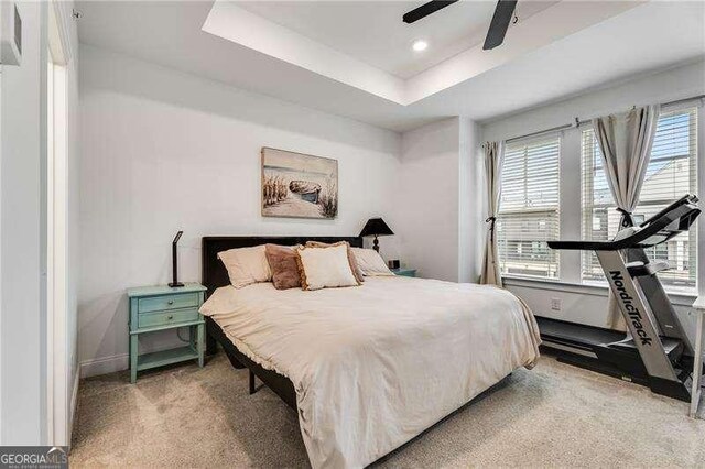 6635 Beacon Dr, Atlanta, GA 30328 - bedroom with multiple windows, light colored carpet, a ceiling fan, and a tray ceiling