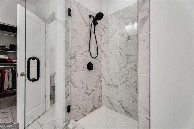 6635 Beacon Dr, Atlanta, GA 30328 - bathroom with a shower stall, a spacious closet, and marble look tiles