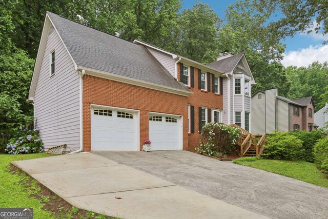 1369 Willowbrook Dr SW, Marietta, GA 30064 - view of front of home featuring driveway, brick siding, and a shingled roof