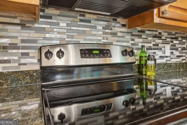 1369 Willowbrook Dr SW, Marietta, GA 30064 - kitchen view of stainless steel range with electric stovetop, backsplash, and premium range hood