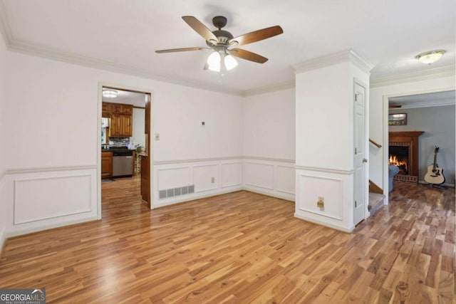 1369 Willowbrook Dr SW, Marietta, GA 30064 - empty room with light wood-type flooring, a ceiling fan, crown molding, a decorative wall, and a wainscoted wall