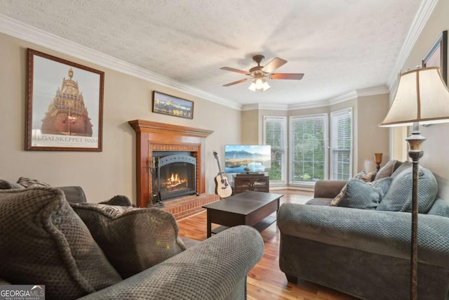 1369 Willowbrook Dr SW, Marietta, GA 30064 - living area with light wood-style floors, a fireplace, ceiling fan, a textured ceiling, and ornamental molding