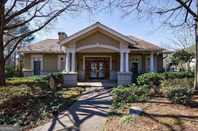 2700 Pine Tree Rd NE Unit 1013, Atlanta, GA 30324 - view of front of property featuring french doors, stucco siding, a chimney, a porch, and a shingled roof