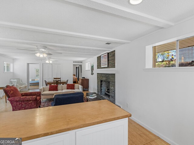 155 Summit View Rd, Jackson, GA 30233 - living area with light wood-style flooring, a fireplace, a ceiling fan, healthy amount of natural light, and beam ceiling