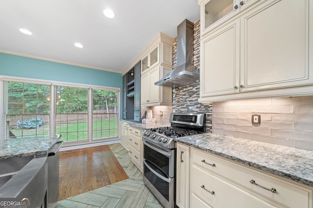 1440 Boundary Blvd, Suwanee, GA 30024 - kitchen featuring appliances with stainless steel finishes, wall chimney range hood, ornamental molding, decorative backsplash, and light stone counters