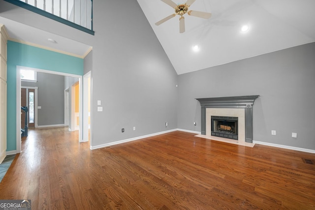 1440 Boundary Blvd, Suwanee, GA 30024 - unfurnished living room featuring high vaulted ceiling, ceiling fan, a fireplace with flush hearth, wood finished floors, and baseboards