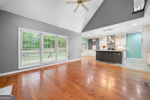 1440 Boundary Blvd, Suwanee, GA 30024 - unfurnished living room with ceiling fan, high vaulted ceiling, baseboards, light wood finished floors, and recessed lighting
