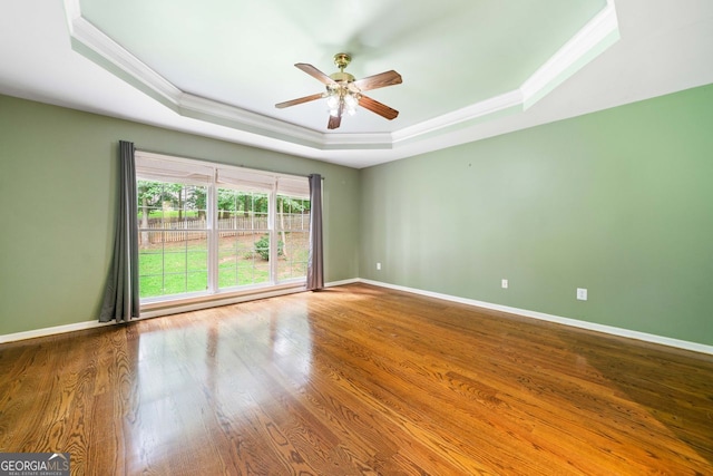1440 Boundary Blvd, Suwanee, GA 30024 - spare room featuring a raised ceiling, ceiling fan, crown molding, wood finished floors, and baseboards