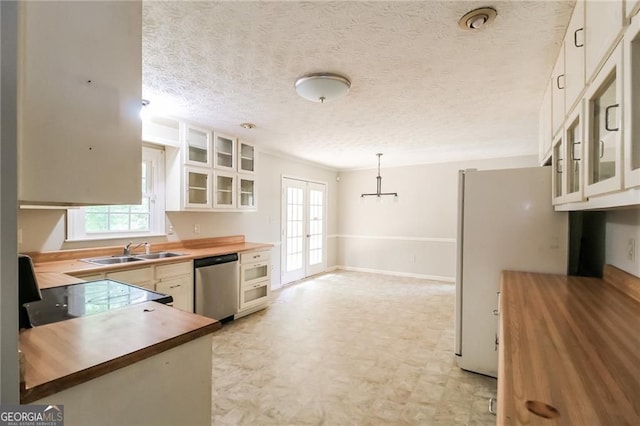 263 Austin Rd, Stockbridge, GA 30281 - kitchen featuring wood counters, dishwasher, white cabinets, glass insert cabinets, and a textured ceiling