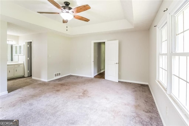 263 Austin Rd, Stockbridge, GA 30281 - unfurnished bedroom featuring carpet, a raised ceiling, ensuite bathroom, and a ceiling fan
