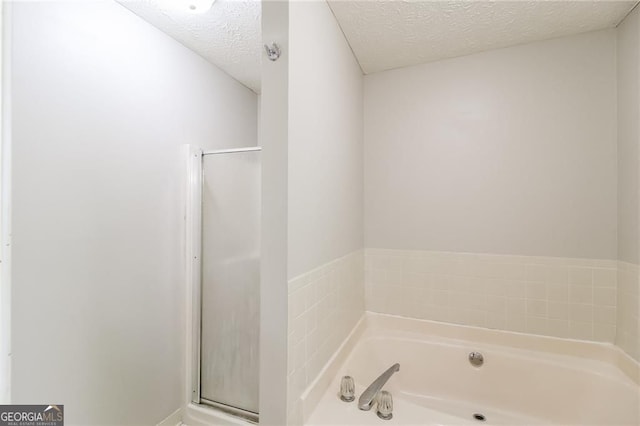 263 Austin Rd, Stockbridge, GA 30281 - full bath featuring a garden tub, a textured ceiling, and a shower stall