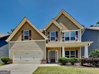 473 Cherry Creek Dr, Loganville, GA 30052 - craftsman-style house with driveway, a front lawn, and a porch