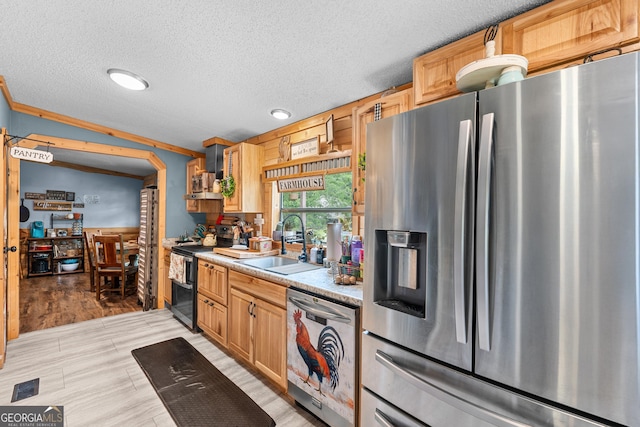 67 Lagoon Rd, Statesboro, GA 30461 - kitchen with stainless steel appliances, a textured ceiling, light countertops, light brown cabinets, and wall chimney range hood