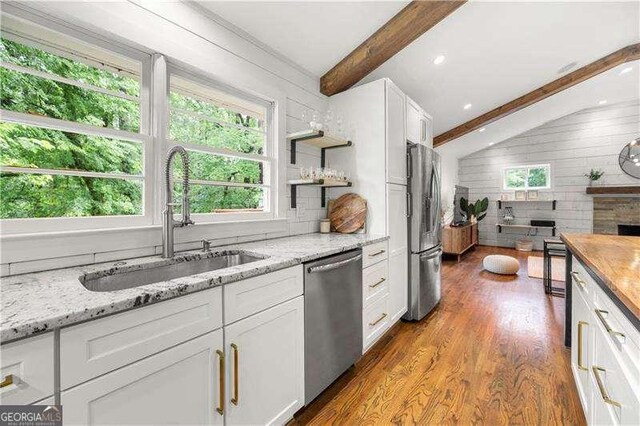 2020 New Kemp Rd, Marietta, GA 30066 - kitchen with appliances with stainless steel finishes, a sink, healthy amount of natural light, wood finished floors, and wood walls