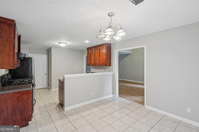 484 Culberson St SW, Atlanta, GA 30310 - kitchen featuring a chandelier, gas range oven, light tile patterned floors, a textured ceiling, and pendant lighting