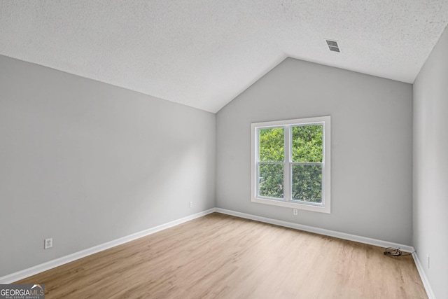 484 Culberson St SW, Atlanta, GA 30310 - empty room featuring wood finished floors, lofted ceiling, and a textured ceiling