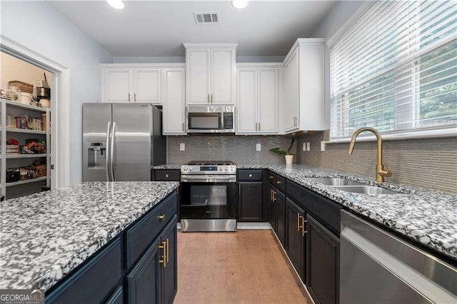 2069 Brightleaf Way Unit 123, Marietta, GA 30060 - kitchen with appliances with stainless steel finishes, a sink, white cabinets, light stone counters, and backsplash