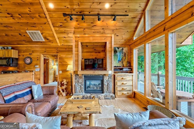 481 Georgianna Ln, Bryson City, NC 28713 - living area with track lighting, vaulted ceiling, wood-type flooring, a fireplace, and wood walls