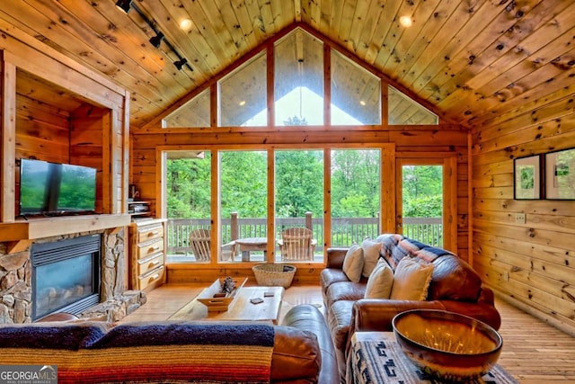 481 Georgianna Ln, Bryson City, NC 28713 - living room with lofted ceiling, healthy amount of natural light, wooden walls, a stone fireplace, and wood finished floors