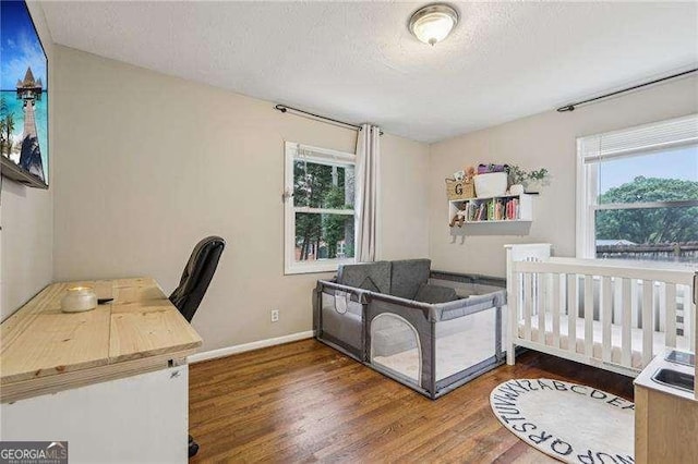3351 Landrum Dr SE, Smyrna, GA 30082 - bedroom with wood finished floors, a textured ceiling, baseboards, and a desk
