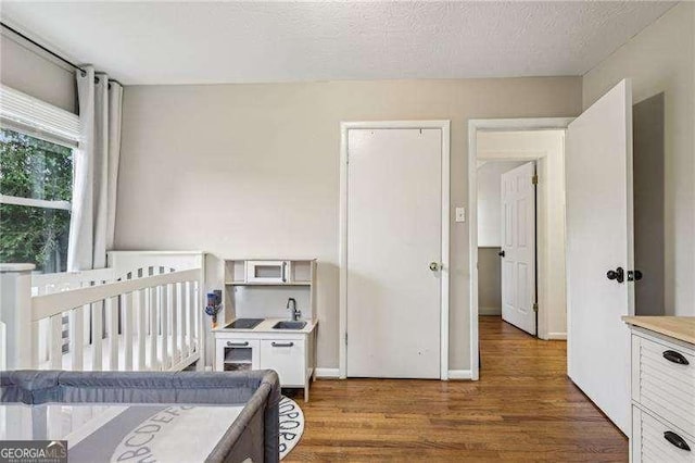 3351 Landrum Dr SE, Smyrna, GA 30082 - bedroom with wood finished floors, a sink, and a textured ceiling