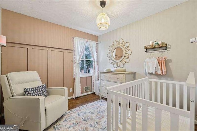 3351 Landrum Dr SE, Smyrna, GA 30082 - bedroom featuring wood finished floors, a nursery area, and wallpapered walls