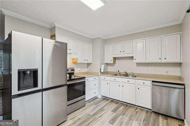 3351 Landrum Dr SE, Smyrna, GA 30082 - kitchen with appliances with stainless steel finishes, under cabinet range hood, a sink, white cabinets, and light wood-style flooring
