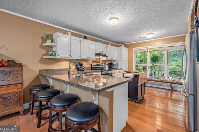 1526 Oakleaf Dr, Auburn, GA 30011 - kitchen featuring appliances with stainless steel finishes, range hood, a sink, ornamental molding, and a peninsula