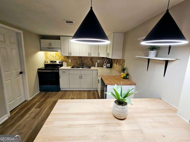 2977 5th St SW, Atlanta, GA 30315 - kitchen with stainless steel range with electric cooktop, under cabinet range hood, tasteful backsplash, dark wood-style flooring, and hanging light fixtures
