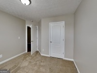 426 Summer Hill Cir, Stockbridge, GA 30281 - carpeted empty room featuring baseboards and a textured ceiling