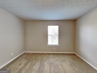 426 Summer Hill Cir, Stockbridge, GA 30281 - carpeted spare room with baseboards and a textured ceiling
