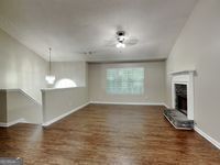 426 Summer Hill Cir, Stockbridge, GA 30281 - unfurnished living room with a fireplace with raised hearth, baseboards, and wood finished floors