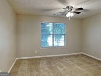 426 Summer Hill Cir, Stockbridge, GA 30281 - unfurnished room with baseboards, ceiling fan, and carpet
