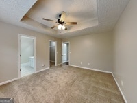 426 Summer Hill Cir, Stockbridge, GA 30281 - unfurnished bedroom featuring a raised ceiling, carpet, baseboards, and ensuite bathroom