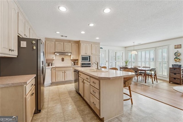 440 Carybell Ln, Alpharetta, GA 30004 - kitchen featuring stainless steel appliances, a sink, a breakfast bar, a textured ceiling, and light brown cabinetry