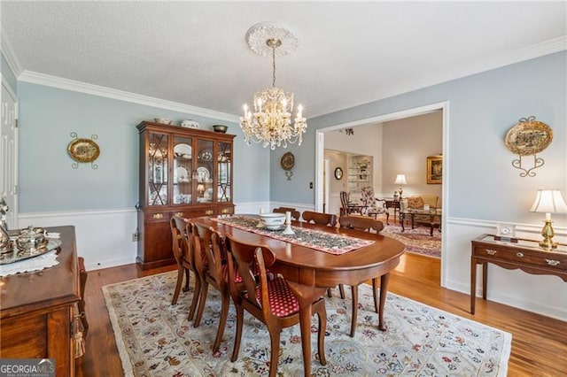 440 Carybell Ln, Alpharetta, GA 30004 - dining space with a chandelier, crown molding, wainscoting, and wood finished floors