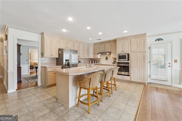 440 Carybell Ln, Alpharetta, GA 30004 - kitchen featuring stainless steel appliances, light countertops, a textured ceiling, a breakfast bar area, and a sink