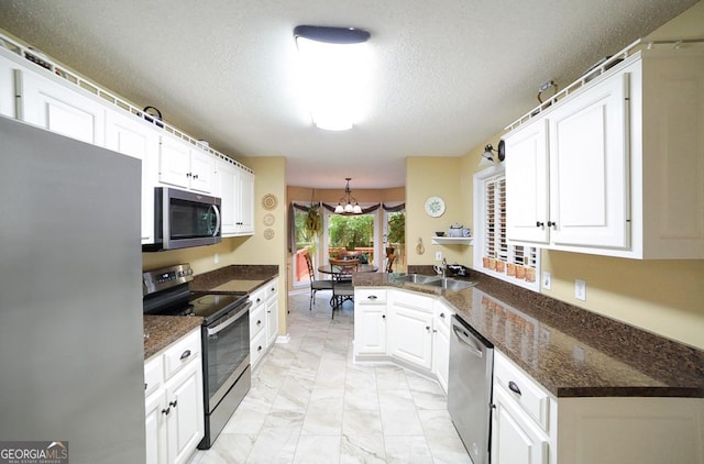 1010 Calls Creek Cir, Watkinsville, GA 30677 - kitchen featuring stainless steel appliances, a sink, a chandelier, light marble finish floors, and a peninsula