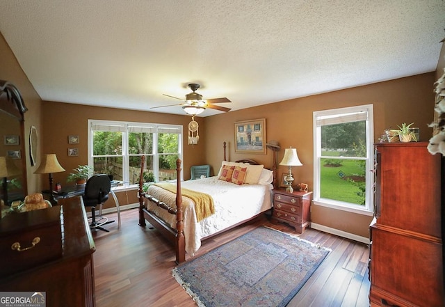 1010 Calls Creek Cir, Watkinsville, GA 30677 - bedroom with wood finished floors, baseboards, a textured ceiling, a ceiling fan, and a desk