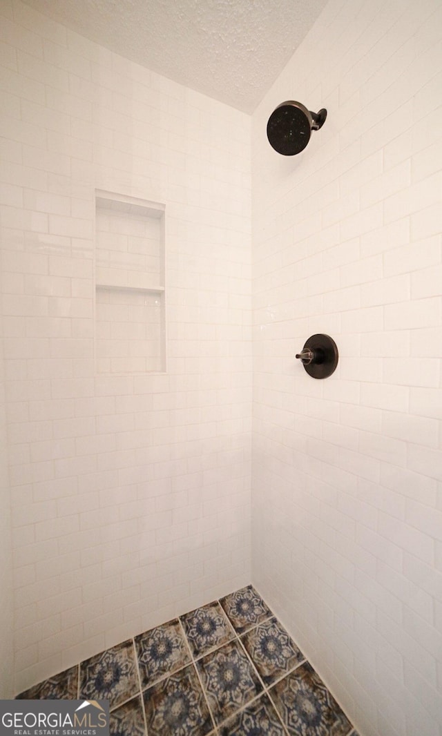 1010 Calls Creek Cir, Watkinsville, GA 30677 - bathroom featuring tiled shower and a textured ceiling