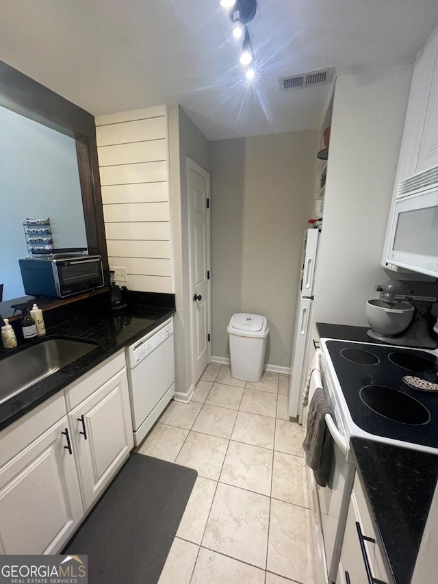 2165 Milledge Dr S Unit B6, Athens, GA 30605 - kitchen with white appliances, dark countertops, light tile patterned floors, and white cabinetry