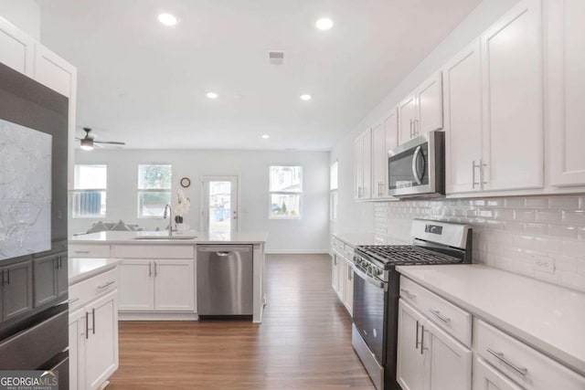 3848 Hester St, Duluth, GA 30097 - kitchen with stainless steel appliances, a ceiling fan, light wood finished floors, decorative backsplash, and recessed lighting