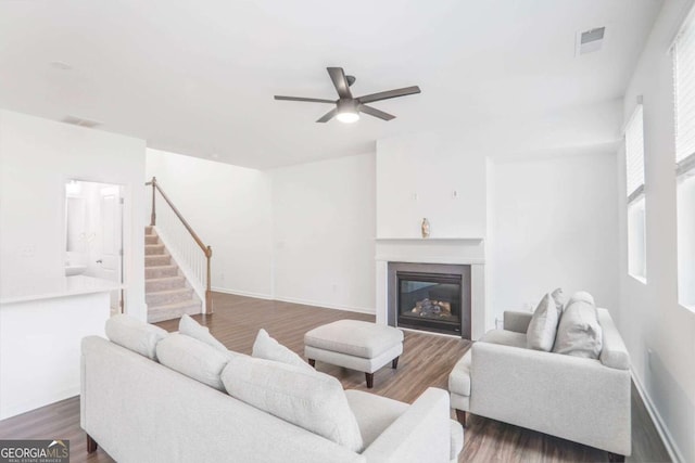 3848 Hester St, Duluth, GA 30097 - living area featuring ceiling fan, dark wood finished floors, stairs, and a glass covered fireplace