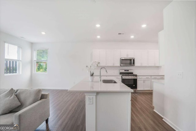 3848 Hester St, Duluth, GA 30097 - kitchen with stainless steel appliances, open floor plan, white cabinetry, dark wood-style flooring, and light countertops