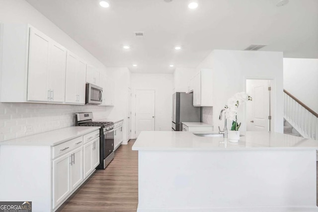 3848 Hester St, Duluth, GA 30097 - kitchen with appliances with stainless steel finishes, white cabinetry, decorative backsplash, recessed lighting, and light countertops