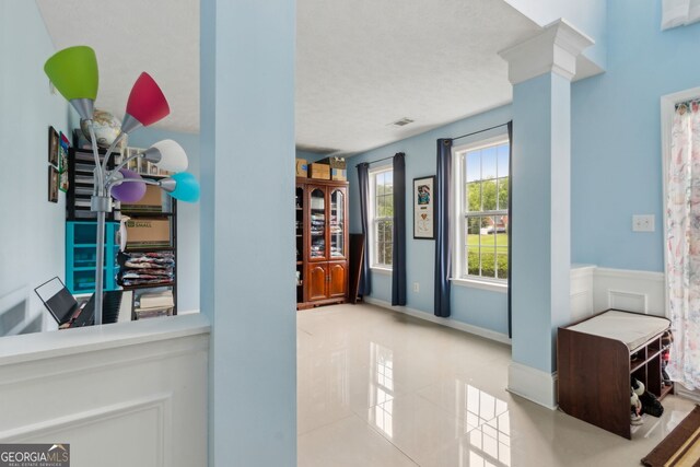 570 White Stag Ct, Suwanee, GA 30024 - corridor with tile patterned flooring, ornate columns, and a textured ceiling