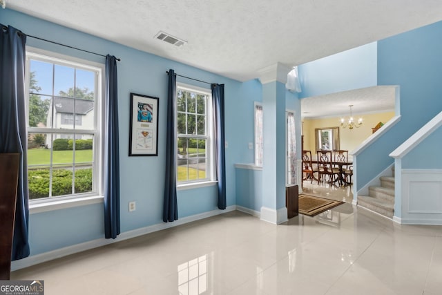570 White Stag Ct, Suwanee, GA 30024 - entrance foyer with a chandelier, tile patterned flooring, a textured ceiling, and stairs