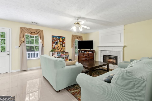 570 White Stag Ct, Suwanee, GA 30024 - living room featuring a ceiling fan, a premium fireplace, light tile patterned floors, and a textured ceiling